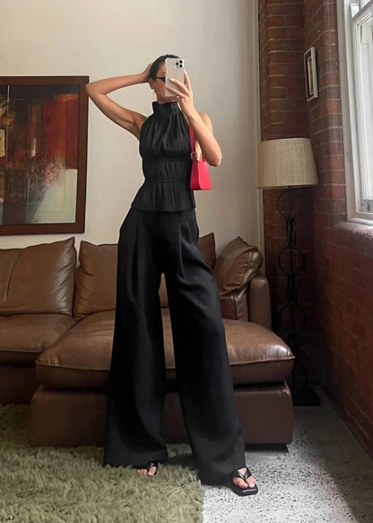 Haut femme dos-nu en tissu léger, orné de détails en chaîne métallique pour un look moderne et élégant.