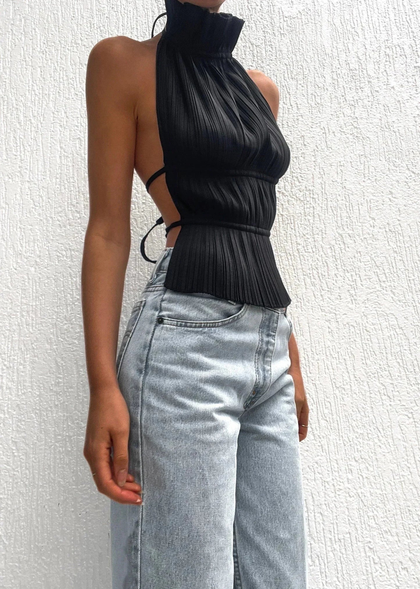 Haut femme dos-nu en tissu léger, détails chaîne métallique pour une touche élégante et moderne. Parfait pour les soirées.