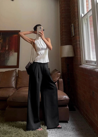 Haut femme dos-nu en tissu léger avec des détails en chaîne métallique sur les bretelles pour un look élégant.