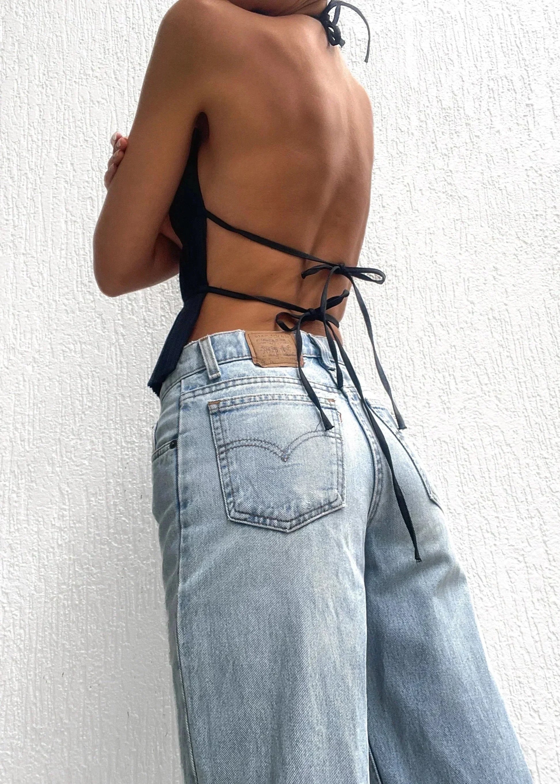 Haut femme dos-nu en polyester, orné de détails chaîne métallique pour un look élégant et moderne.