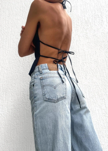 Haut femme dos-nu en polyester, orné de détails chaîne métallique pour un look élégant et moderne.