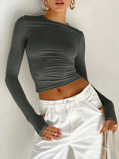 Haut femme noir à manches longues, extensible, coupe ajustée en tissu doux et respirant.