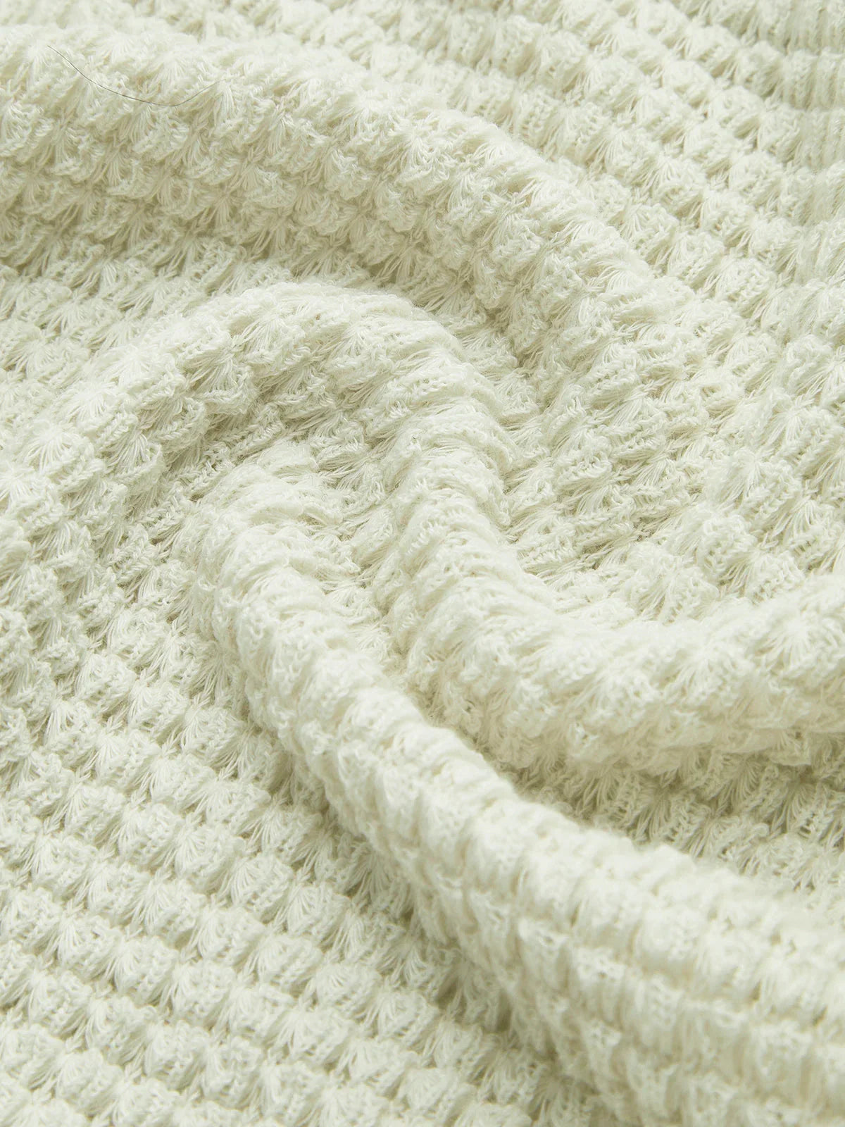 Haut noir à manches longues en maille texturée, adapté pour des tenues d'automne.