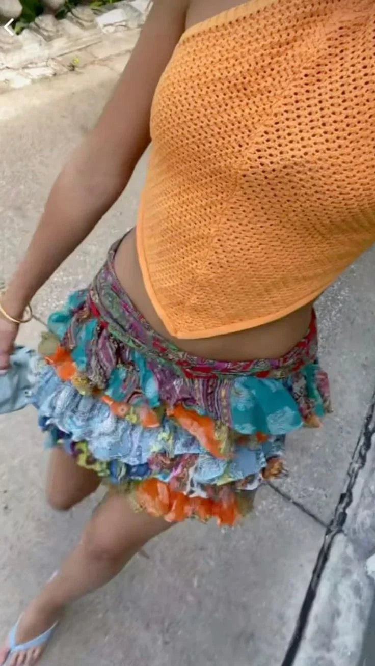 Jupe courte femme en coton multicolore, ornée de volants et de motifs floraux pour un look estival.