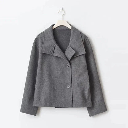 Manteau court femme bleu foncé avec boutons et col montant, conçu pour les journées fraîches.