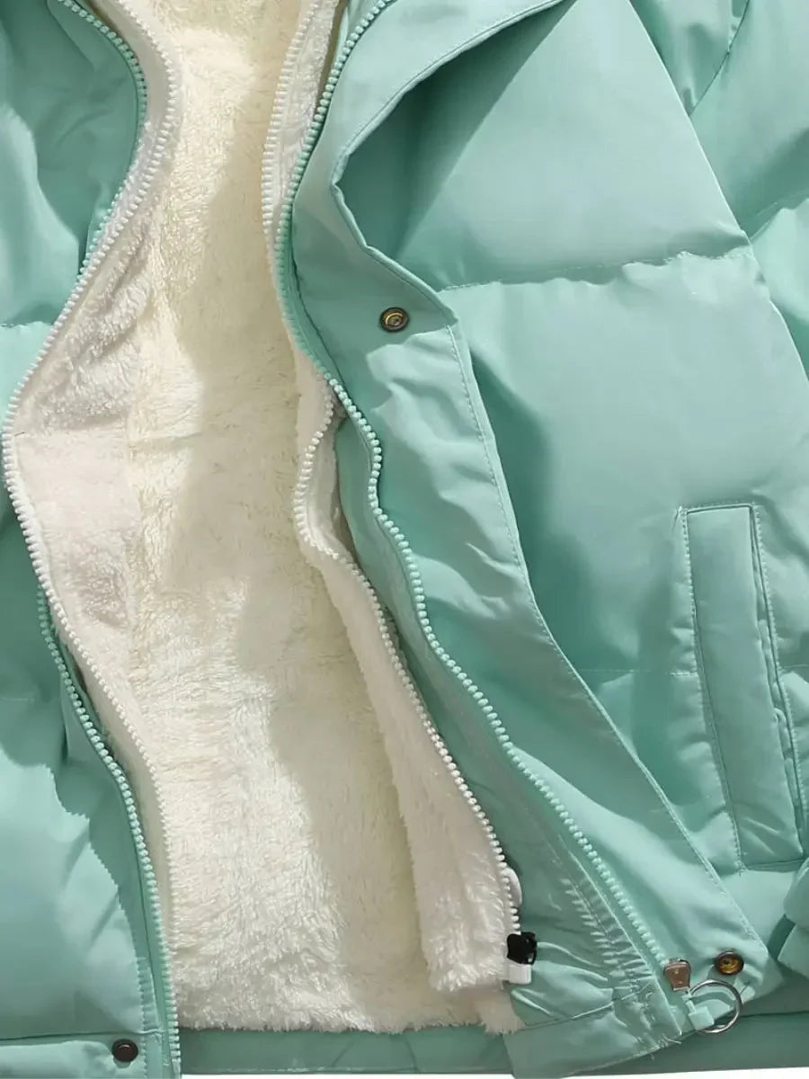 Doudoune d'hiver femme bleue avec capuche, doublure en polaire et extérieur résistant au vent.