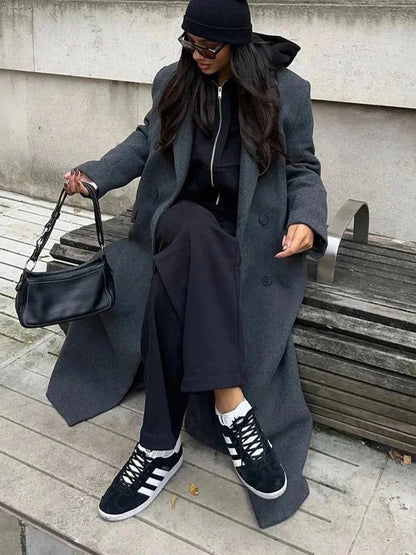 Manteau d'hiver femme noir, coupe oversize, en matériau chaud, avec poches pratiques et design moderne.