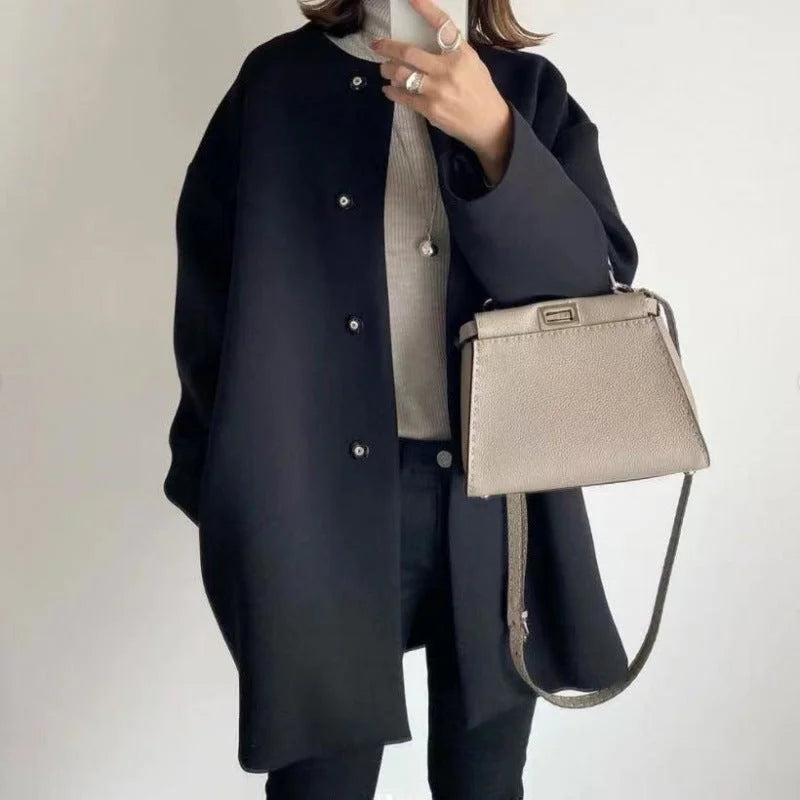 Manteau noir pour femme avec boutons, coupe moderne et en mélange de laine pour les journées fraîches.