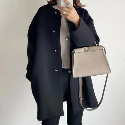 Manteau noir pour femme avec boutons, coupe moderne et en mélange de laine pour les journées fraîches.