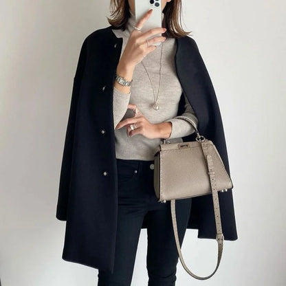 Manteau femme noir en laine avec boutons, design moderne, adapté pour la mi-saison et diverses occasions.