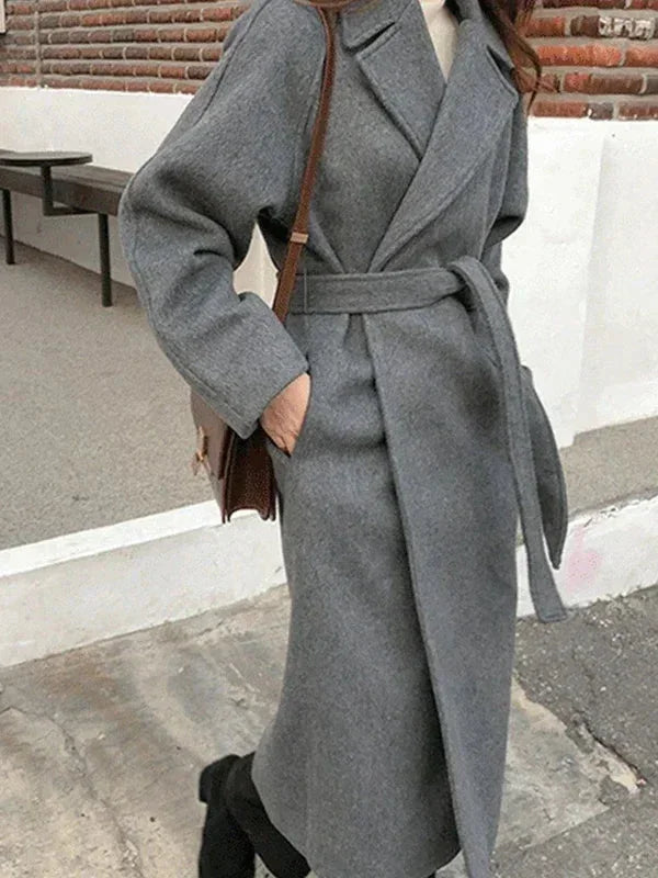 Manteau long marron pour femme avec ceinture, col chic et tissu doux, adapté pour les jours frais.