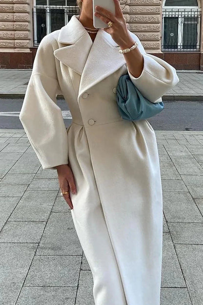 Manteau long blanc pour femme, col large, silhouette minimaliste, en tissu doux.
