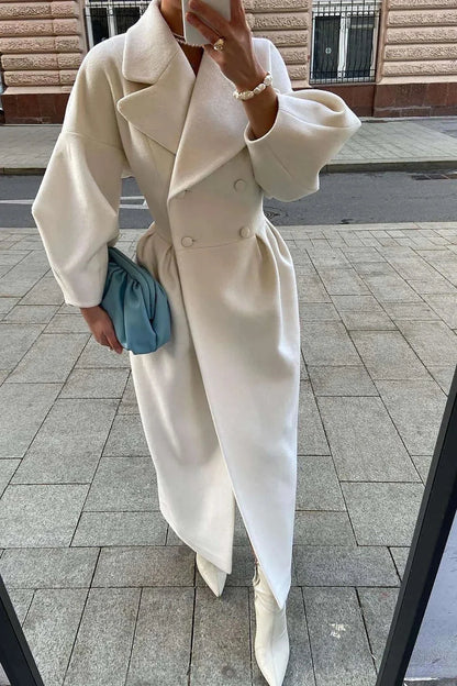Manteau long blanc pour femme avec col large, design minimaliste et coupe élégante.