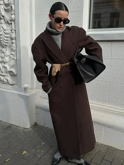 Manteau long marron pour femme, manches volumineuses, coupe ajustée, idéal pour des occasions élégantes.
