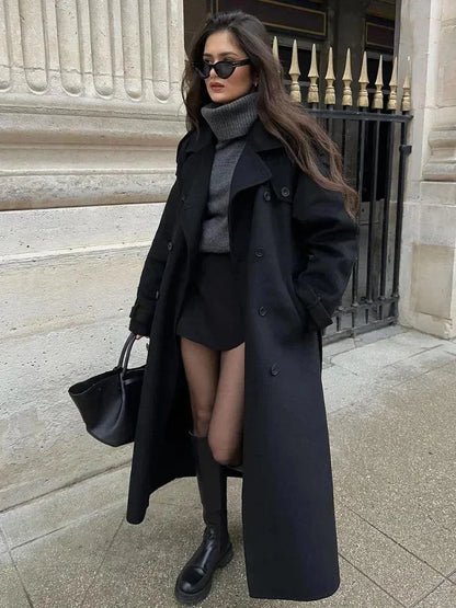 Manteau long noir femme, ceinture à la taille, larges revers, en tissu chaud pour un style décontracté.