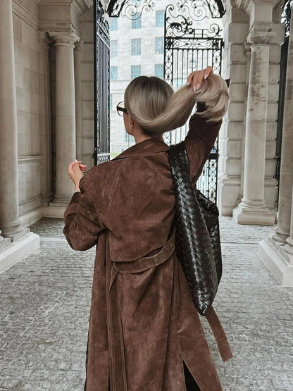 Manteau trench femme marron avec ceinture et revers, conçu pour les saisons intermédiaires.