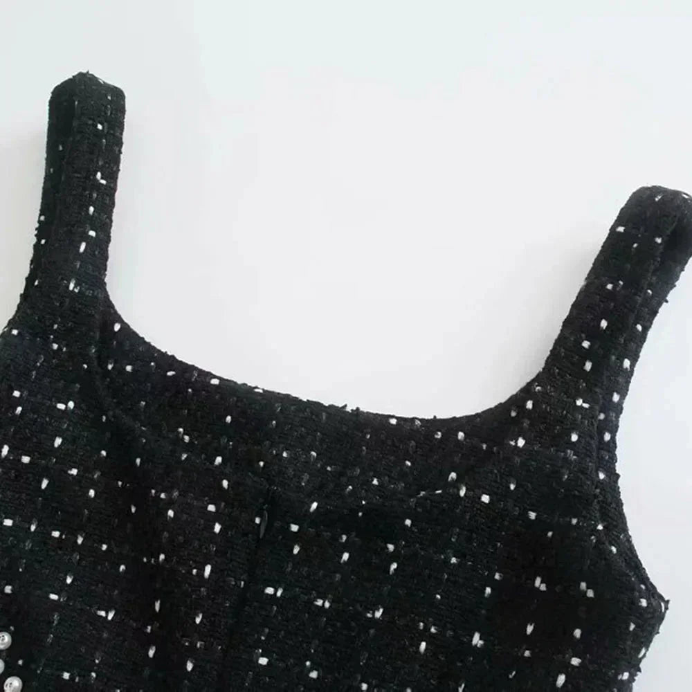Mini robe noire perlée avec découpes, manches épaules nues, en tissu fluide et élégant, idéale pour soirées et événements.