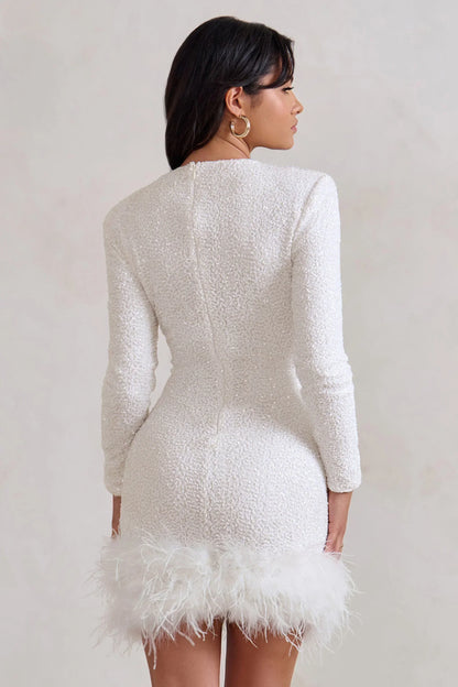 Mini robe noire femme, manches longues, ourlet en plumes, tissu léger et fluide pour un confort élégant.