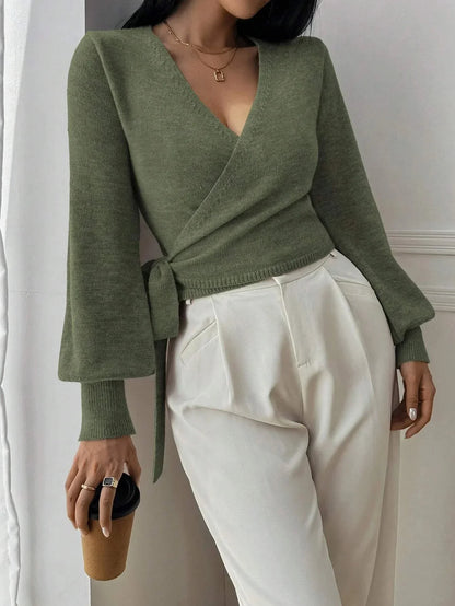 Pull cache-cœur noir pour femme en tricot doux avec ceinture à nouer, adapté pour des tenues décontractées ou élégantes.
