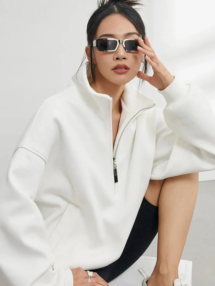 Pull à capuche femme oversize blanc en coton, avec demi-zip et coupe décontractée.