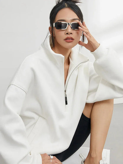 Pull à capuche femme oversize blanc en coton, avec demi-zip et coupe décontractée.