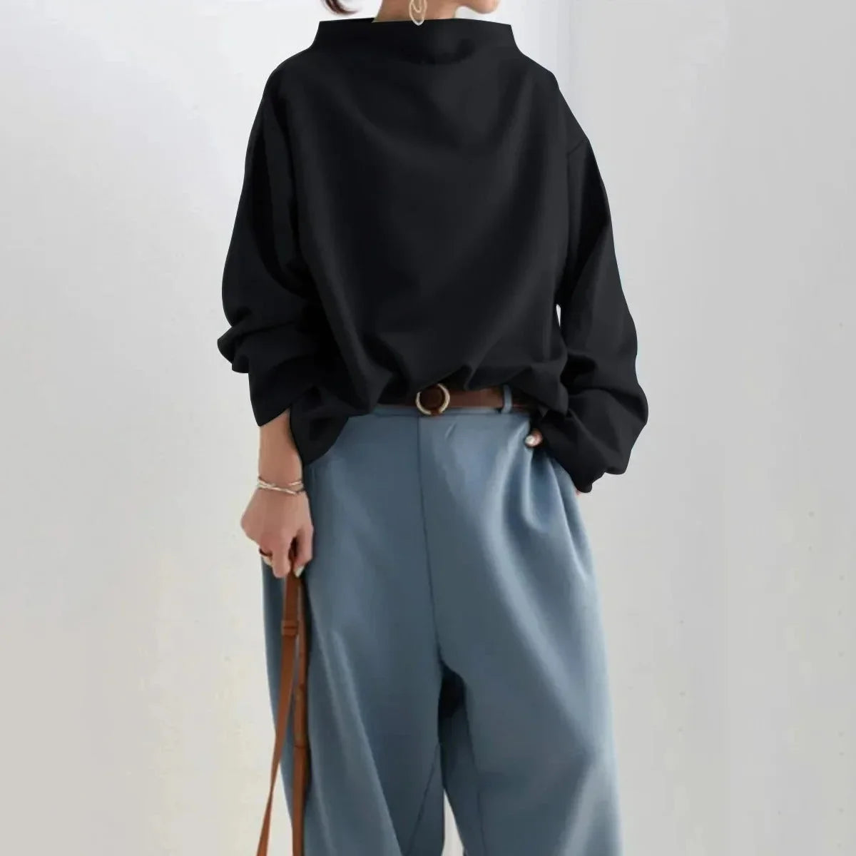 Pull col haut noir pour femmes, en matière douce et respirante, au design moderne et épuré.