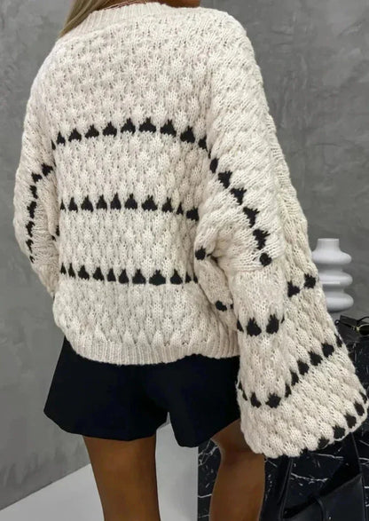 Pull en maille texturée noir avec design géométrique, adapté pour un style décontracté.