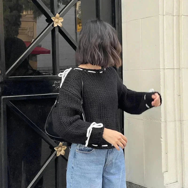 Pull femme asymétrique rose avec attaches, en matière douce, pour un style moderne.