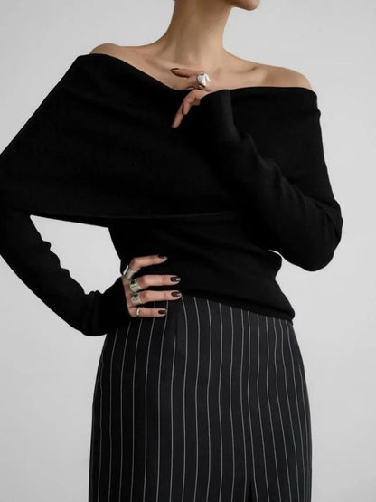 Pull femme gris à col bateau, manches longues, en matière douce et respirante.
