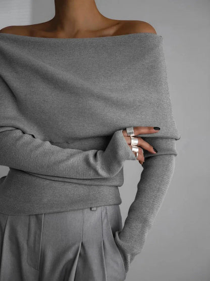 Pull femme gris à col bateau, manches longues, en matière douce.