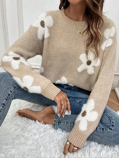 Pull femme en coton, à col rond, avec motifs floraux colorés sur un fond uni, idéal pour un style décontracté.