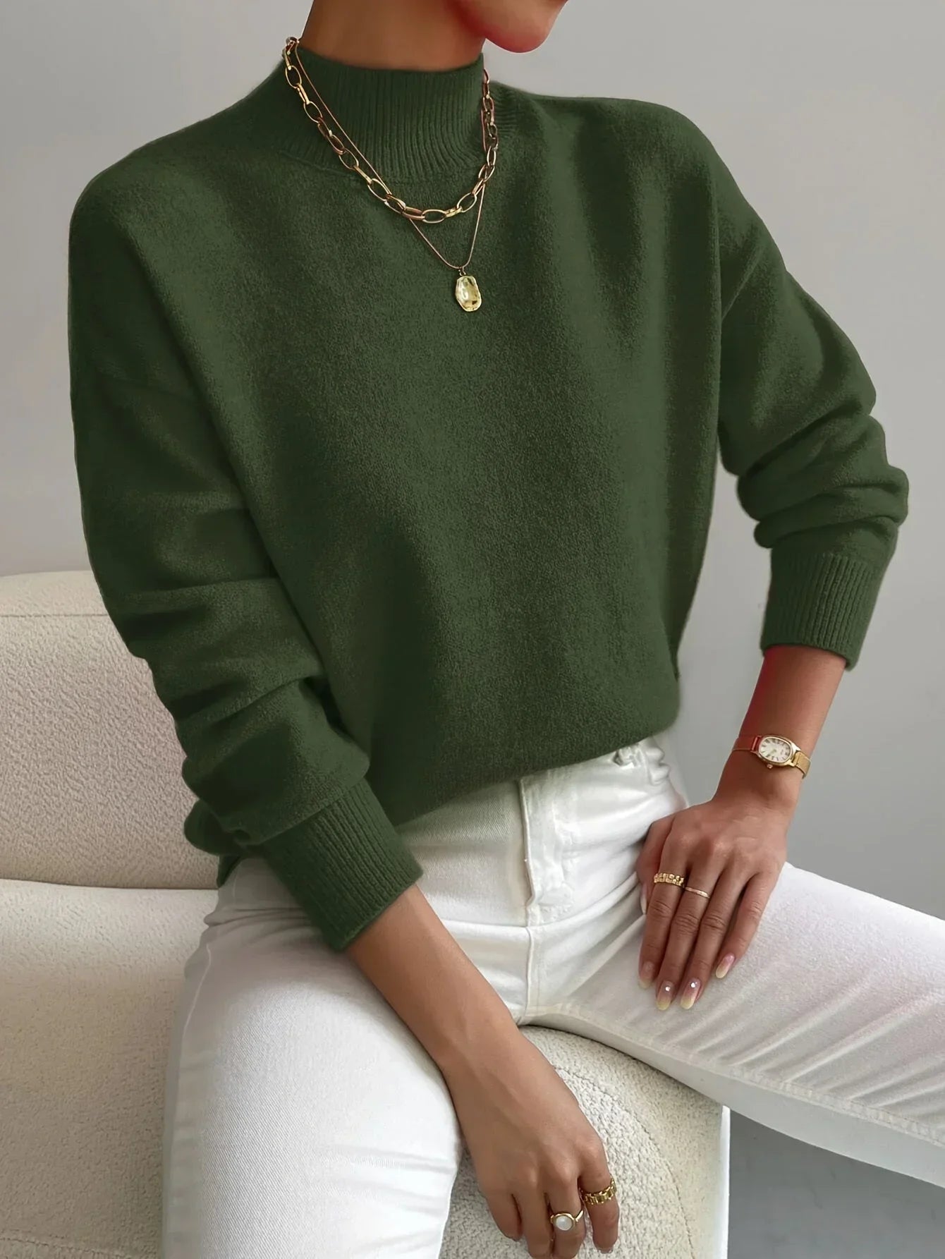 Pull féminin rose clair, col montant, en tissu extensible, manches longues, design simple et intemporel.