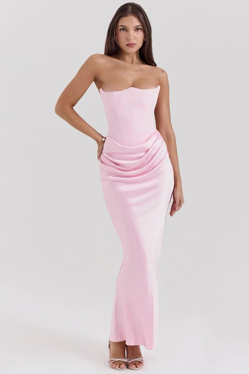 Robe bustier maxi drapée en rose bébé, confectionnée en tissu léger, avec une coupe fluide et des détails élégants.