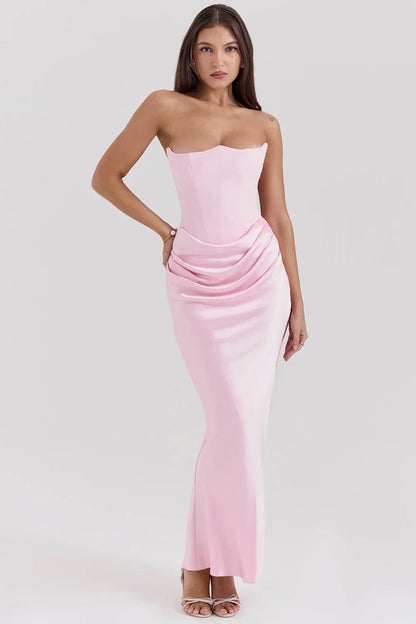 Robe bustier maxi drapée en rose bébé, confectionnée en tissu léger, avec une coupe fluide et des détails élégants.