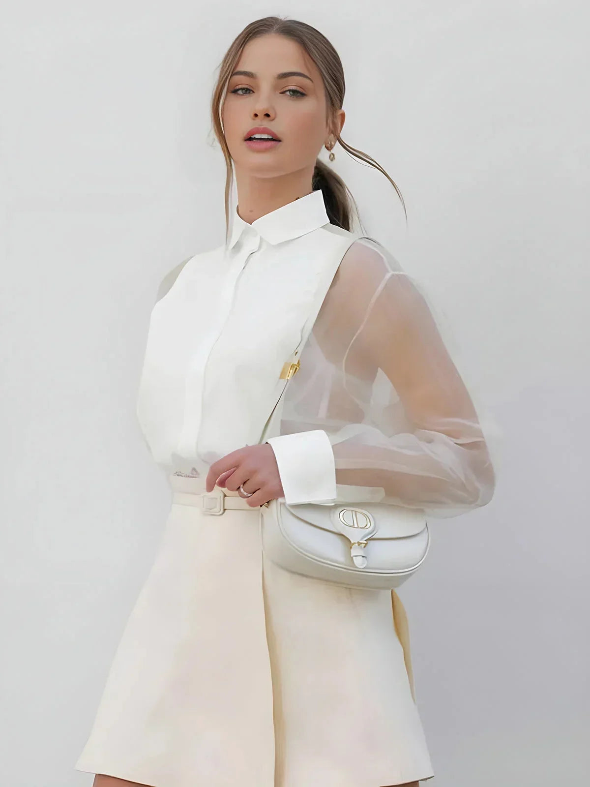 Robe courte blanche avec col chemise, manches transparentes en tissu léger, parfaite pour un look professionnel élégant.