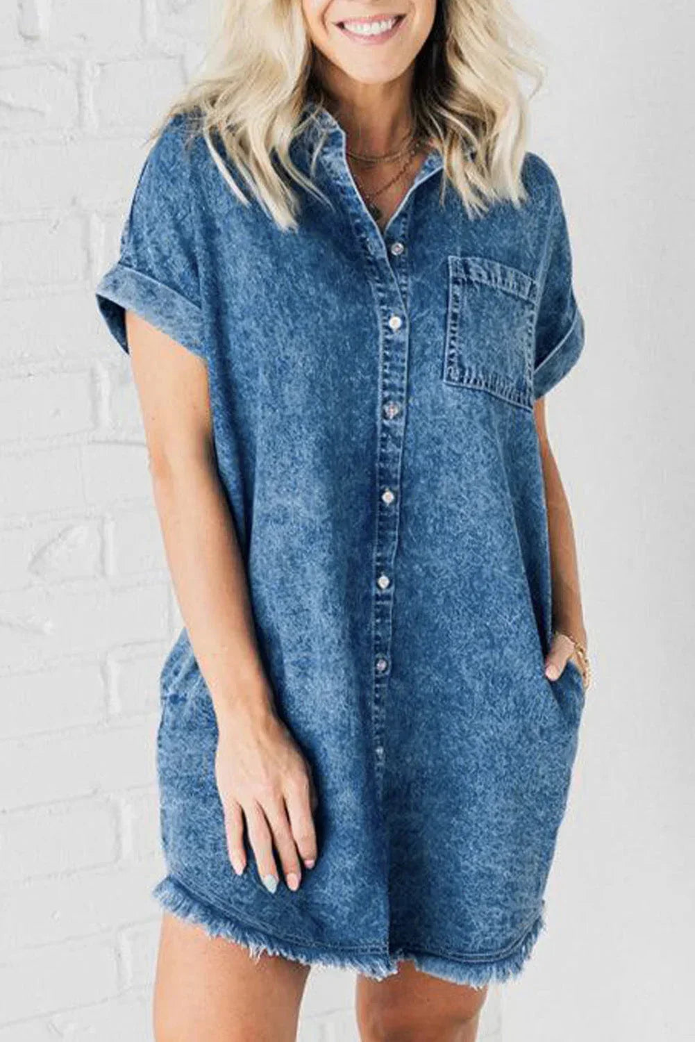 Robe courte en denim bleu, boutons sur le devant, manches courtes et col classique, idéale pour un look décontracté d'été.