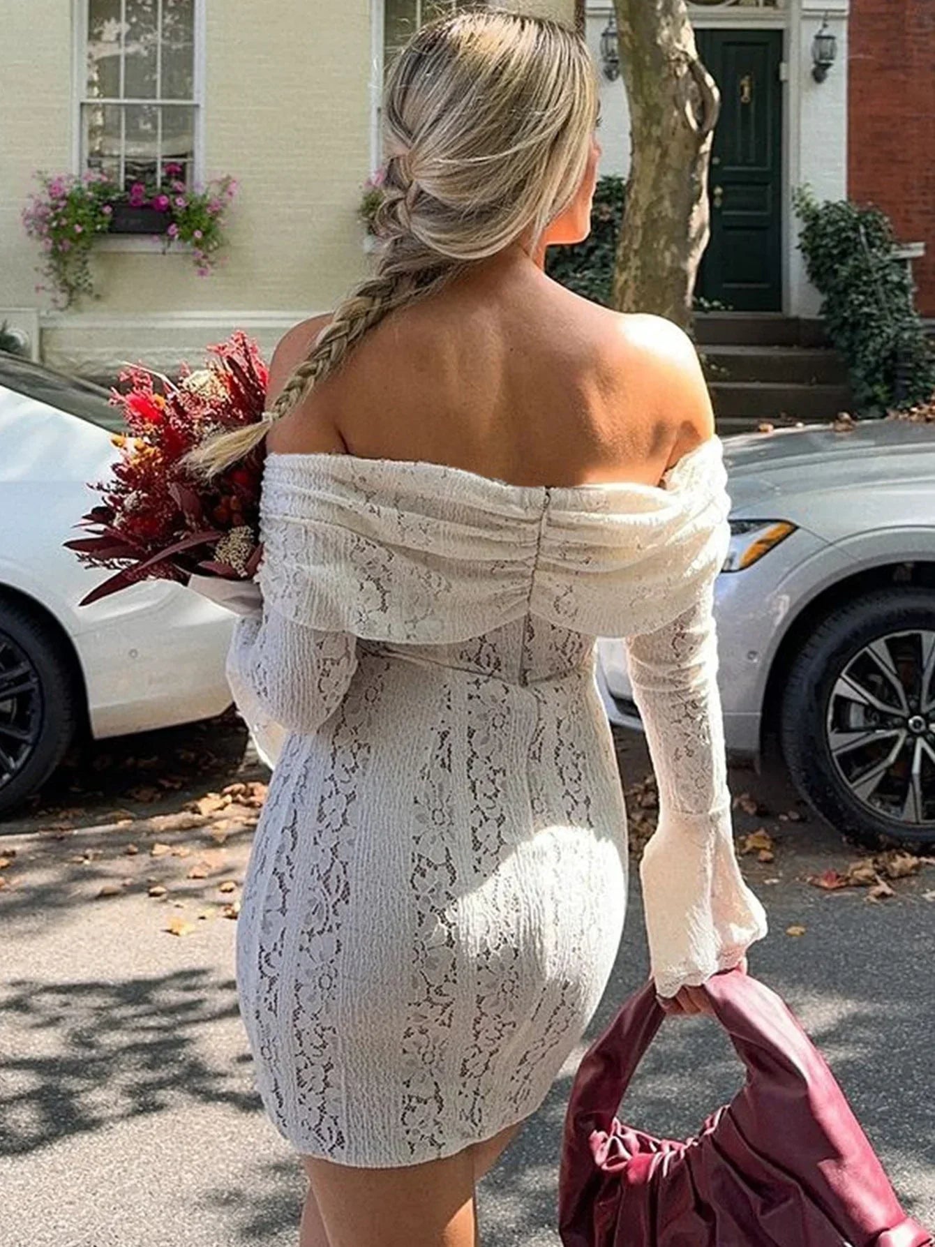 Robe courte en dentelle blanche, à épaules dénudées, avec un design floral et une finition délicate.