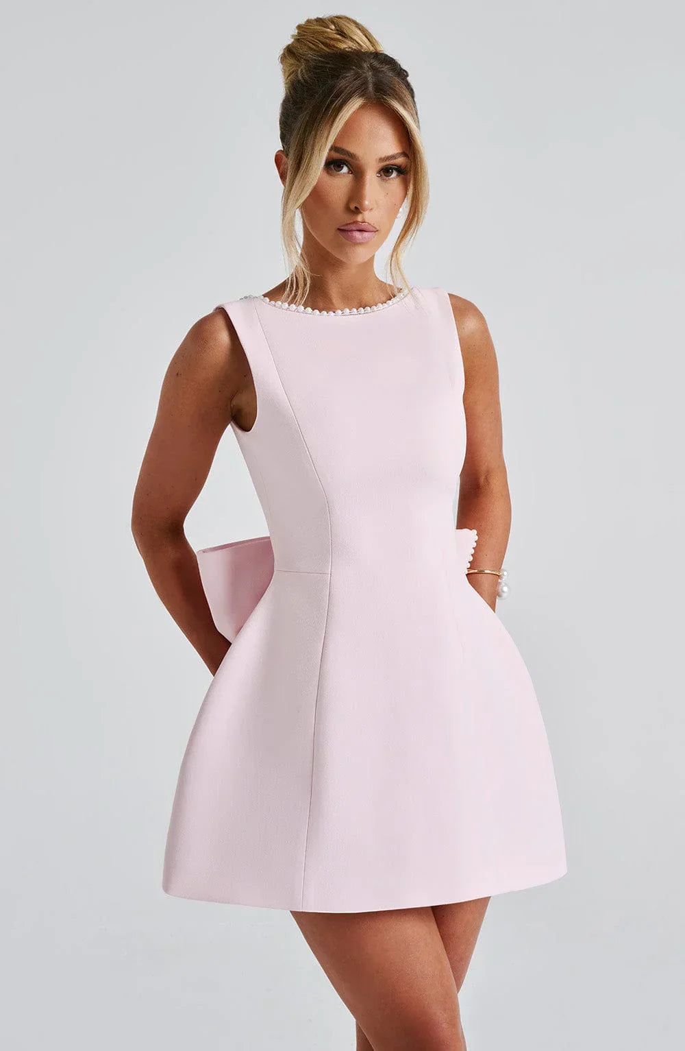 Robe courte en tissu léger avec nœud décoratif au dos, parfaite pour les sorties estivales.