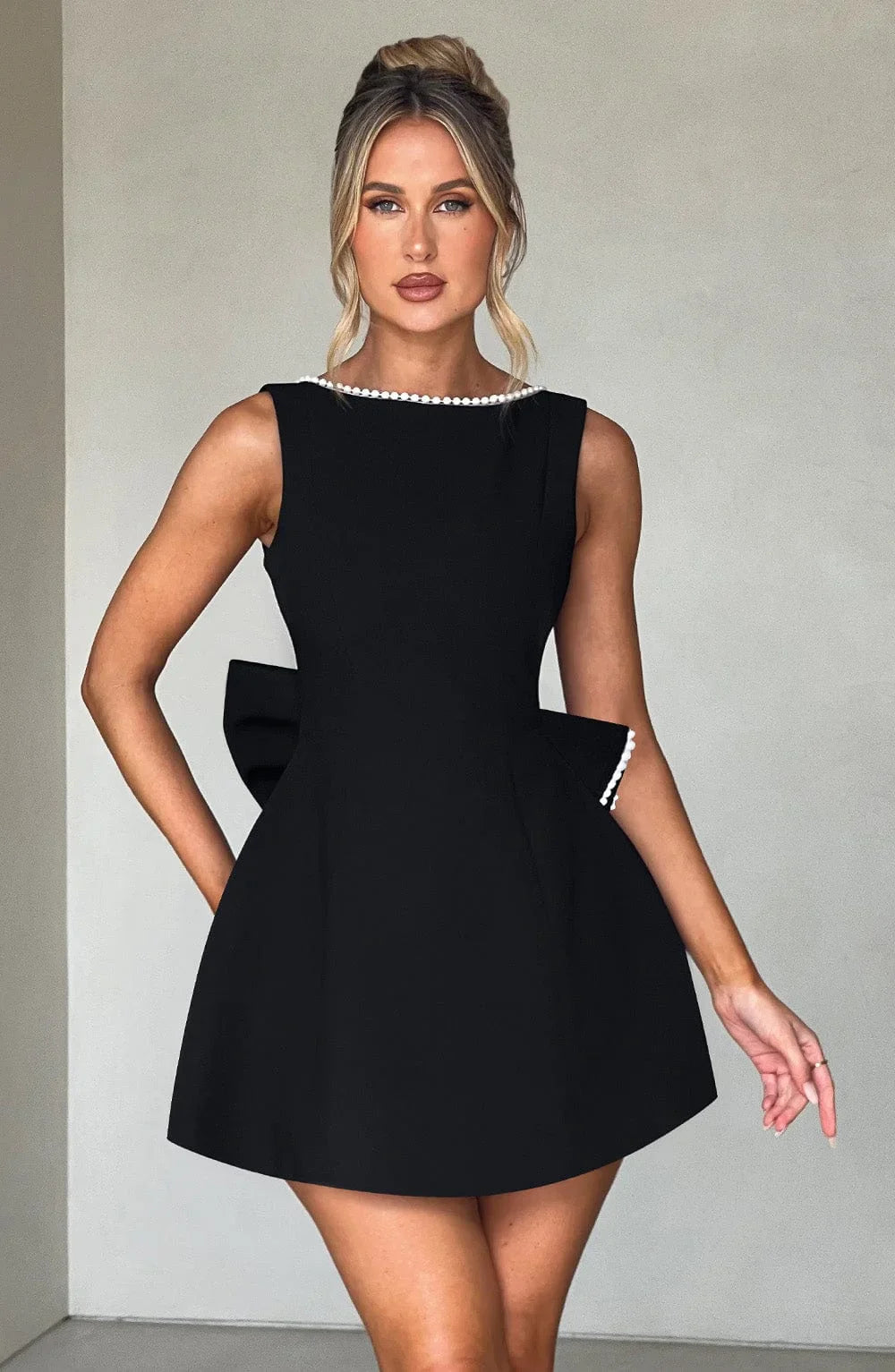 Robe courte femme en coton léger, avec nœud décoratif au dos et coupe ajustée pour un style élégant et décontracté.