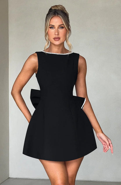 Robe courte femme en coton léger, avec nœud décoratif au dos et coupe ajustée pour un style élégant et décontracté.