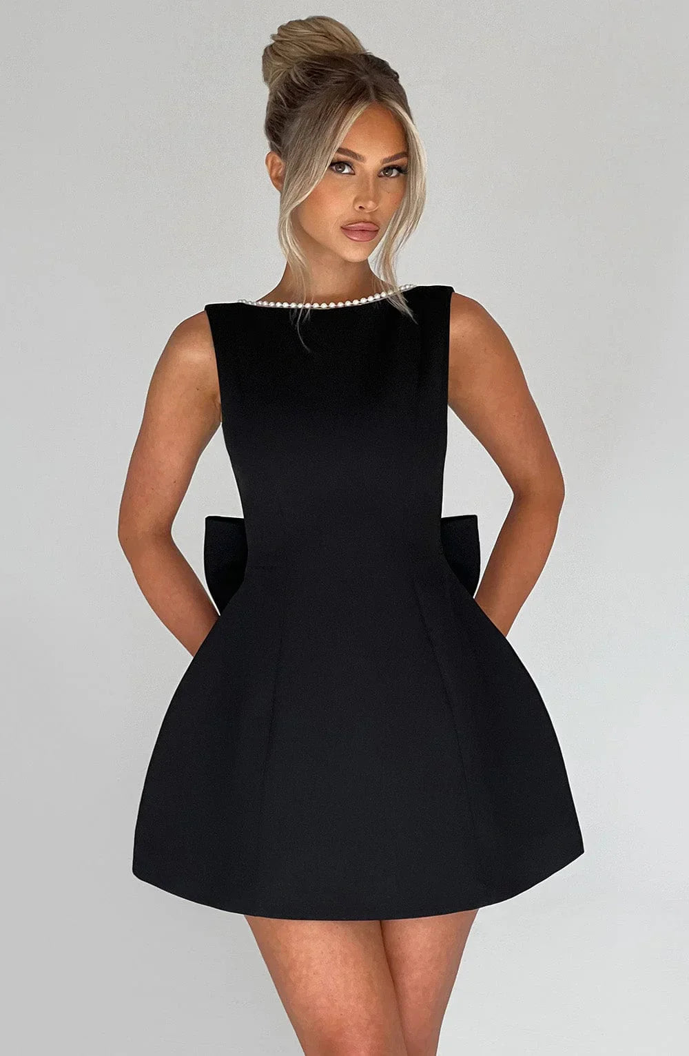 Robe courte femme en tissu léger avec nœud décoratif au dos, parfaite pour les journées estivales.