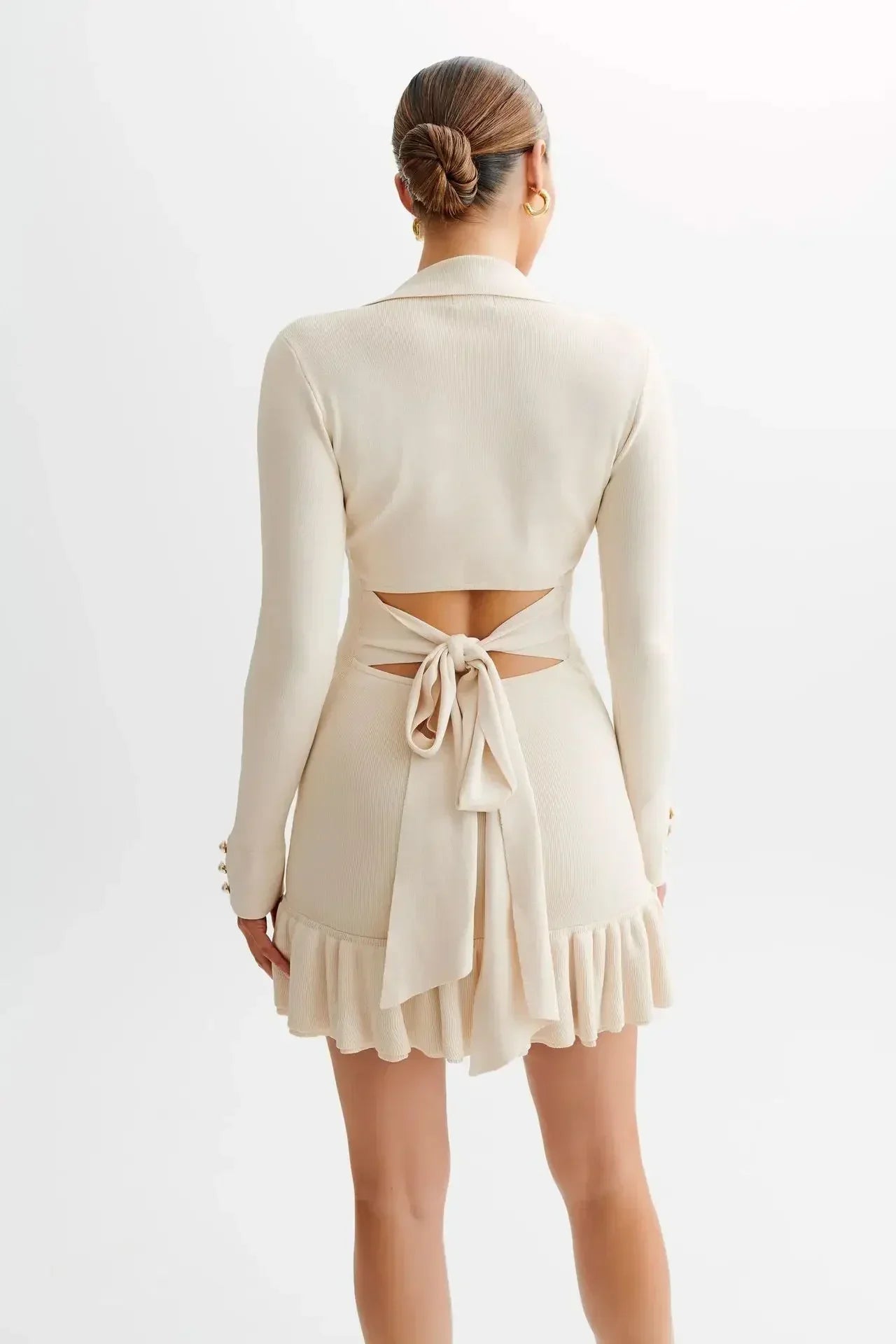Robe courte en coton avec volants délicats et boutons distinctifs, parfaite pour un look décontracté et élégant.