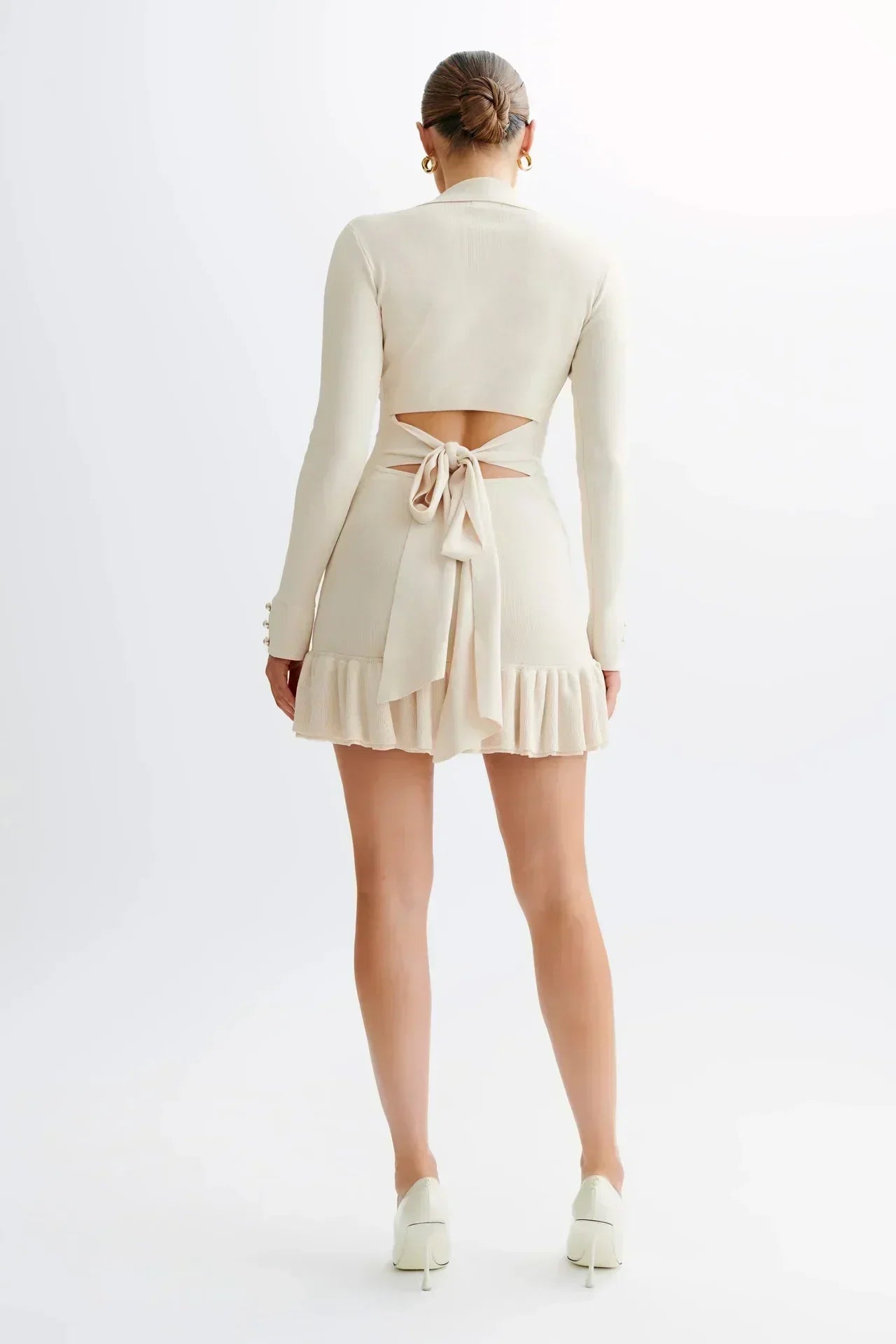Robe courte en tissu léger, avec volants élégants et boutons distinctifs, parfaite pour les occasions décontractées.