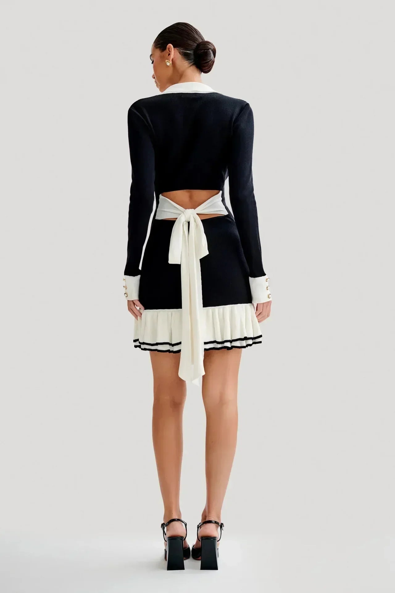 Robe courte femme en tissu léger, avec volants élégants et boutons distinctifs pour un look décontracté et chic.