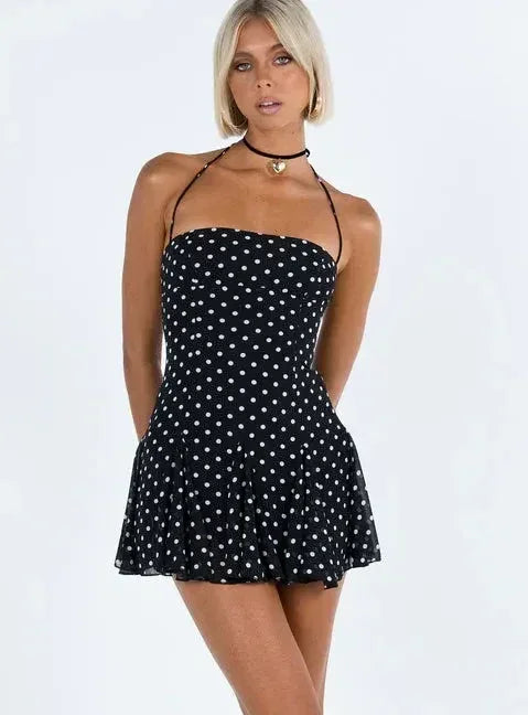 Robe courte femme noire à pois, bretelles fines, en coton léger pour un style décontracté et confortable.