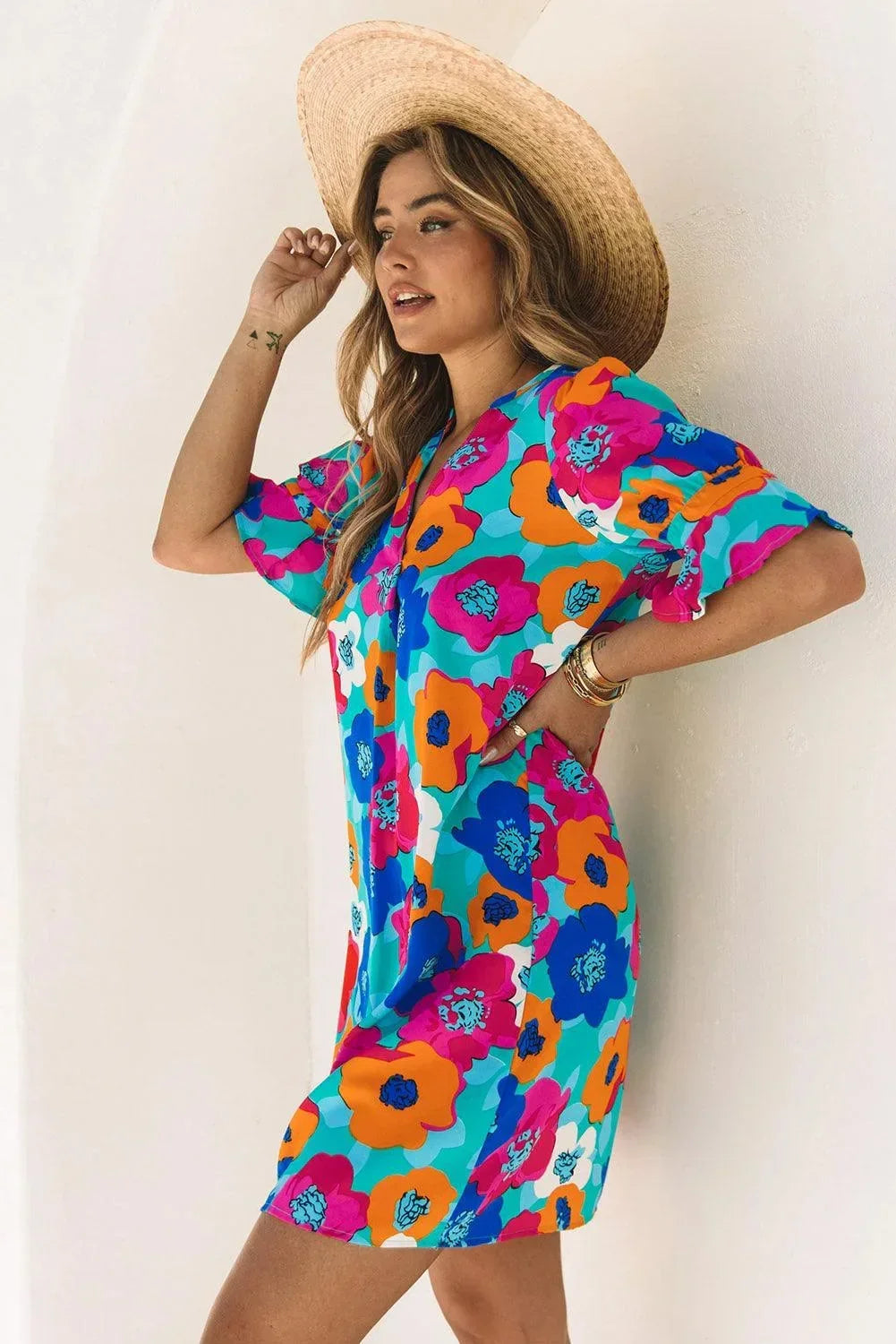 Robe courte à fleurs en tissu léger, col en V, manches 3/4, idéale pour les journées d'été à la plage.