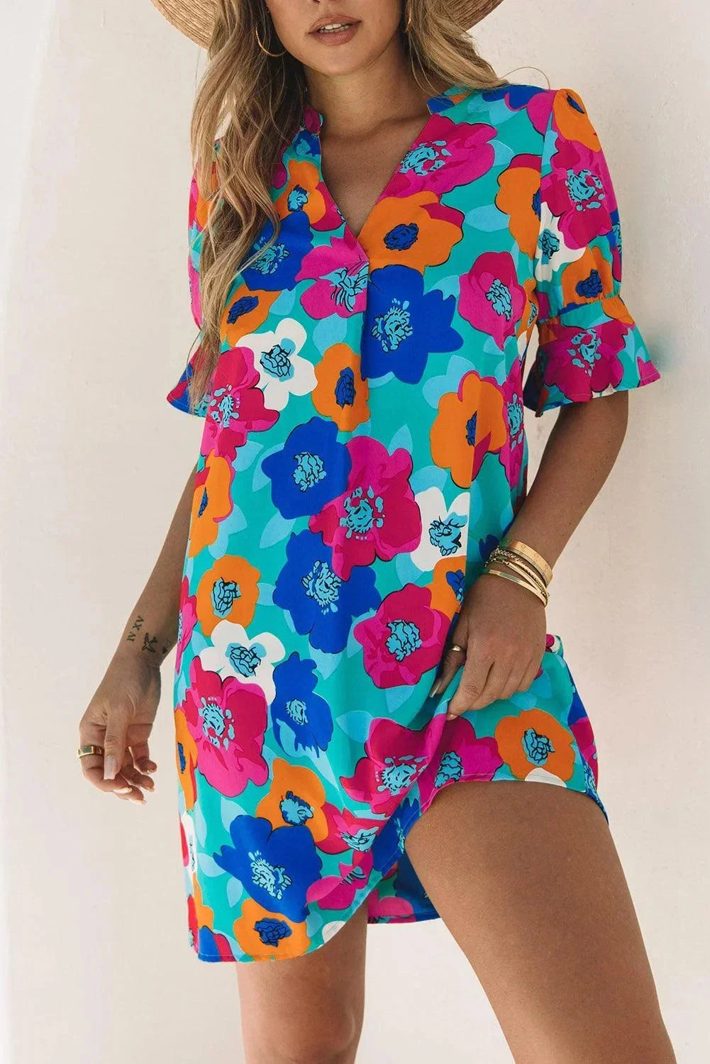 Robe courte à fleurs, col V, manches 3/4, en tissu léger idéal pour l'été et les vacances à la plage.