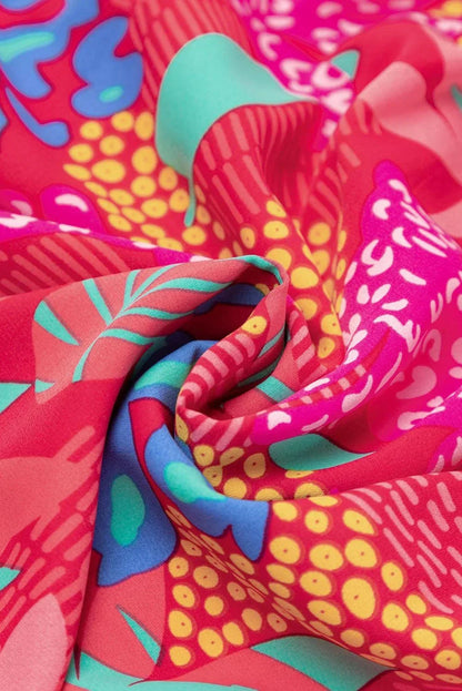 Robe courte rose vif à manches évasées, en tissu léger idéal pour l'été, avec un imprimé coloré et un design décontracté.