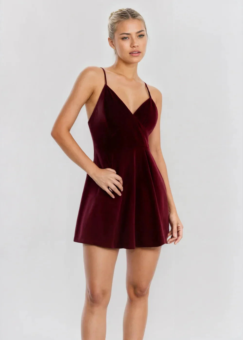 Robe courte en velours bordeaux avec col V, silhouette patineuse, idéale pour des soirées élégantes.