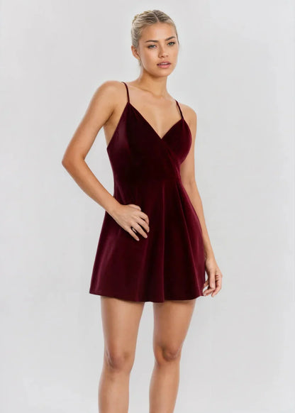 Robe courte en velours bordeaux avec col V, silhouette patineuse, idéale pour des soirées élégantes.